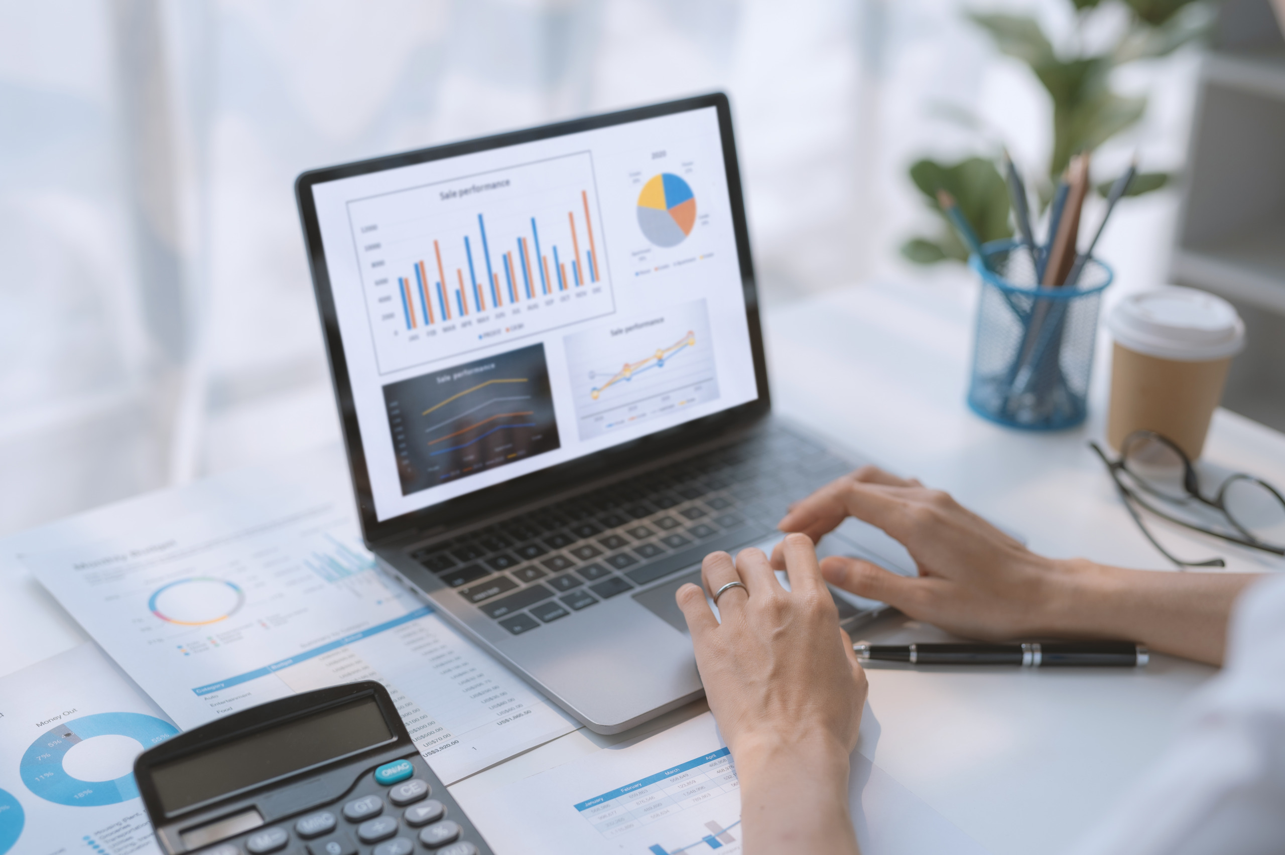 woman working on laptop computer with graphs, charts, diagrams o